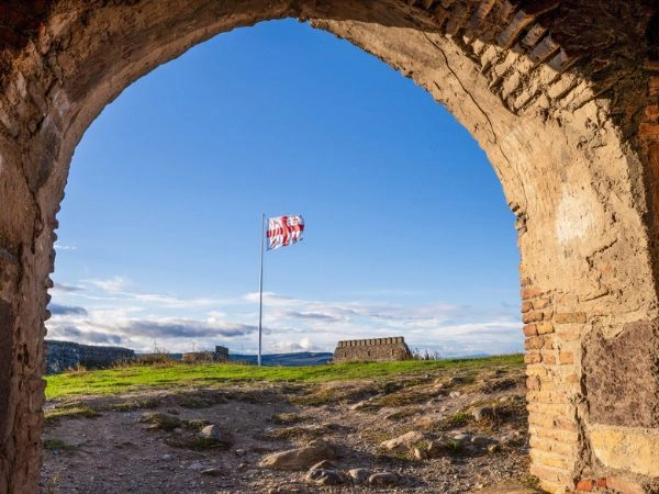 Bandiera georgiana incorniciata da un'antica arcata di pietra nella fortezza di Gori