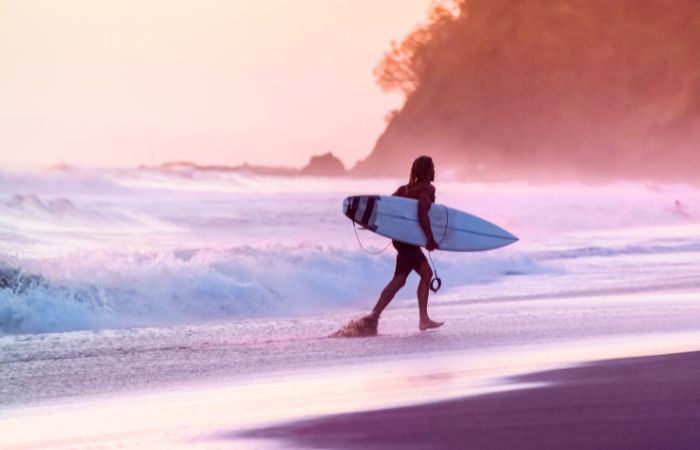 uomo sulla spiaggia con surf