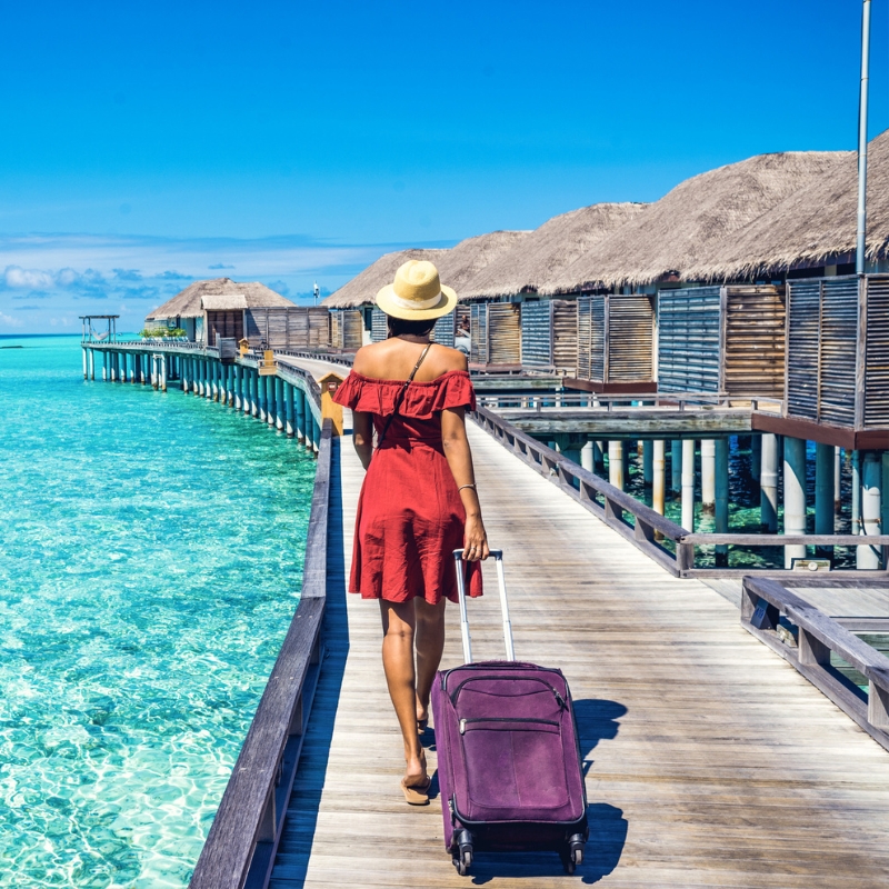 Turista con valigia pronta per una vacanza memorabile nell’Oceano Indiano. Turista con valigia pronta per una delle vacanze alle Maldive più memorabile nell'Oceano Indiano.